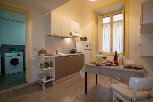 a kitchen with a table and a sink in a room at Sichelgaita Apartment in Salerno