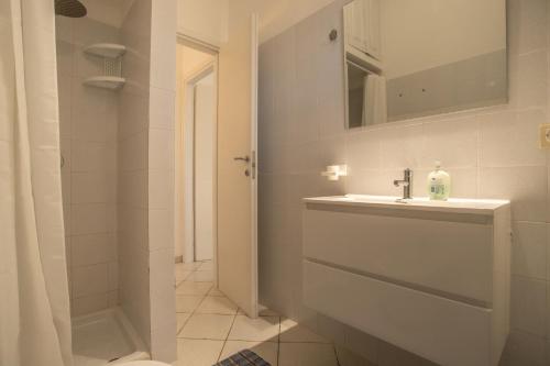 a white bathroom with a sink and a mirror at Villetta Bianca in Lampedusa