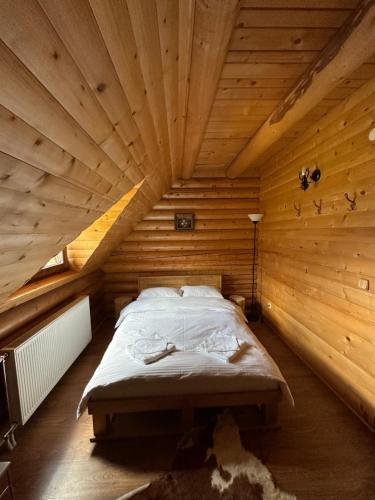 a bedroom with a bed in a wooden room at Après CHALET in Comandău