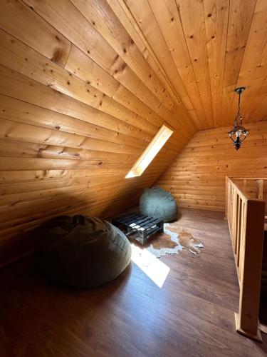 a room with a wooden ceiling and a room with two bean bags at Après CHALET in Comandău