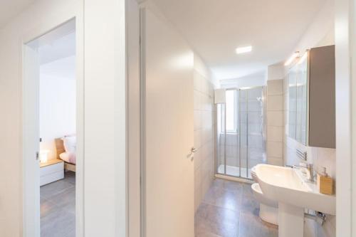 a white bathroom with a sink and a mirror at KHL APARTMENTS in Milan