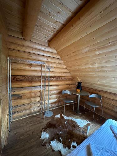 a room with a wooden wall with a table and chairs at Après CHALET in Comandău