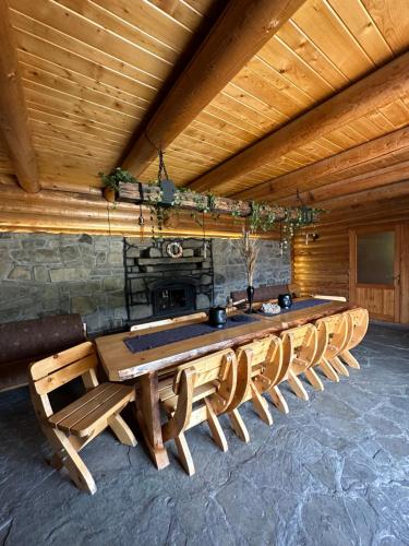 a long wooden table and chairs in a room at Après CHALET in Comandău