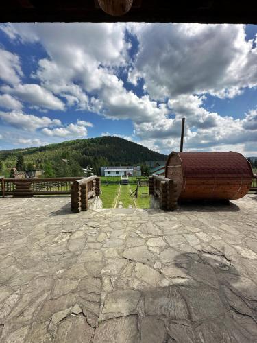 a large wooden barrel sitting on top of a field at Après CHALET in Comandău