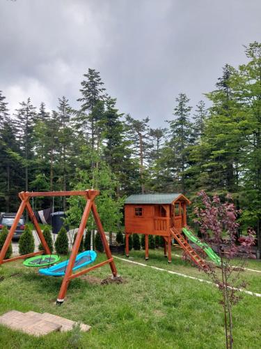 a playground with two swings and a house at Apartmani Borova Iglica Divčibare in Divčibare