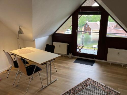 a table and chairs in a room with a large window at Ferienwohnung Teichblick -Balkon- in Dresden