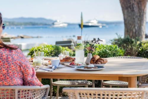 ポルト・ヴェッキオにあるCasa Santini x Roc Sevenの食べ物が置かれたテーブルに座っている女性