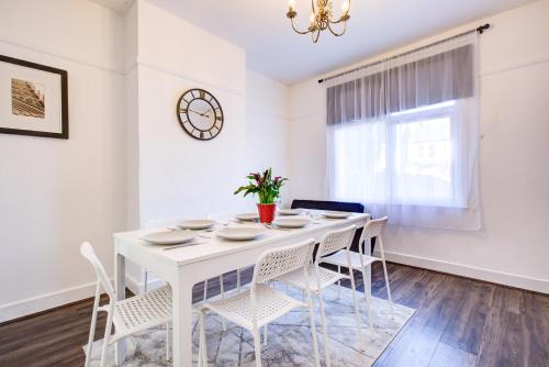 a white dining room with a white table and chairs at Pass the Keys Large house in heart of Southend in Southend-on-Sea