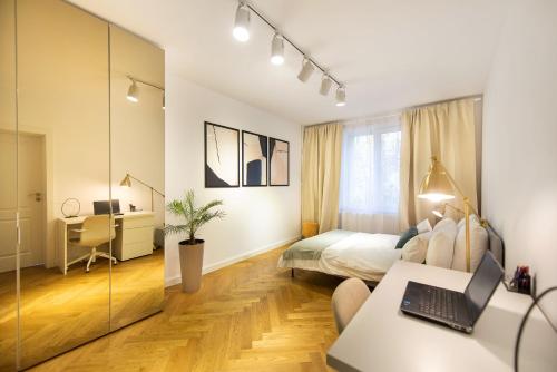 1 dormitorio con 1 cama y escritorio con ordenador portátil en Floreasca View by CityLife Suites, en Bucarest