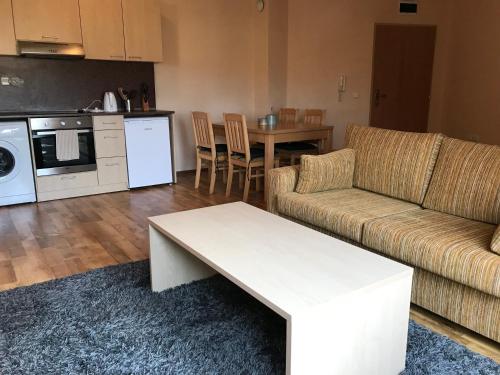 een woonkamer met een bank en een tafel bij Loft Apartment in the fabulous Oasis Beach Resort, Kamchia in Dolen Bliznak
