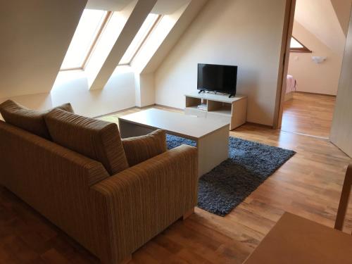 een woonkamer met een bank en een tv bij Loft Apartment in the fabulous Oasis Beach Resort, Kamchia in Dolen Bliznak