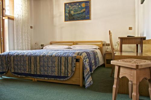 Schlafzimmer mit einem Bett und einem Tisch in der Unterkunft Albergo Ristorante Iris in Auronzo di Cadore