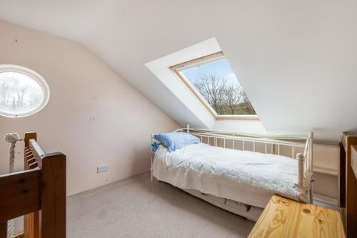 um quarto no sótão com uma cama e uma janela em The Bull Pen em Millom