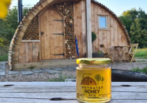um pote de mel sentado numa mesa em frente a uma casa em Fox Lodge at Heygates Lodging - with hot tub 
