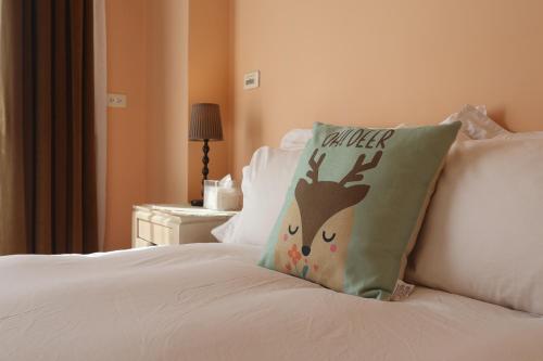 a bed with a pillow with a deer head on it at 干城小鎮民宿-包棟-寵物友善 in Jian