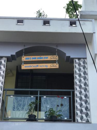 a sign hanging over a window of a building at Gods own home stay in Cochin