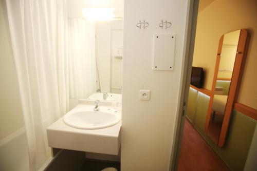 a white bathroom with a sink and a mirror at ibis budget Nantes Sainte Luce in Sainte-Luce-sur-Loire