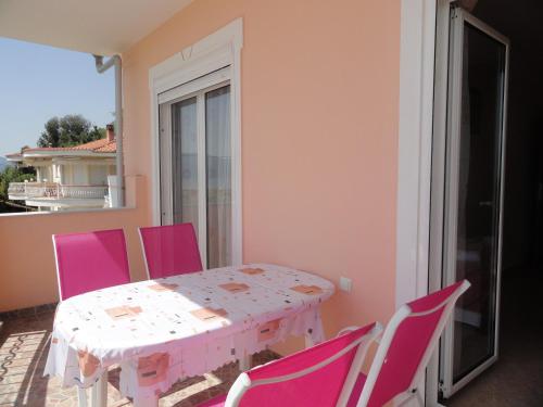 a room with a table and chairs on a balcony at Pension Delfini in Asprovalta