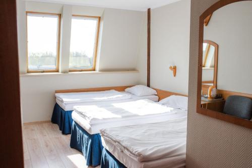 Hotel Kliper في فواديسوافوفو: سريرين في غرفة بها نافذتين