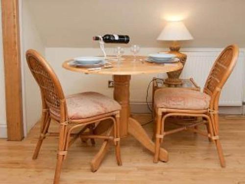 a wooden table with two chairs and a table with a lamp at Owls Nest - Peace and Tranquility near Woodbridge & Framlingham in rural Suffolk in Woodbridge