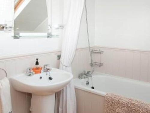 y baño blanco con lavabo y bañera. en Owls Nest - Peace and Tranquility near Woodbridge & Framlingham in rural Suffolk en Woodbridge