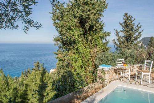 a villa with a swimming pool and a view of the ocean at Agios Nikitas Nature Villas in Komílion