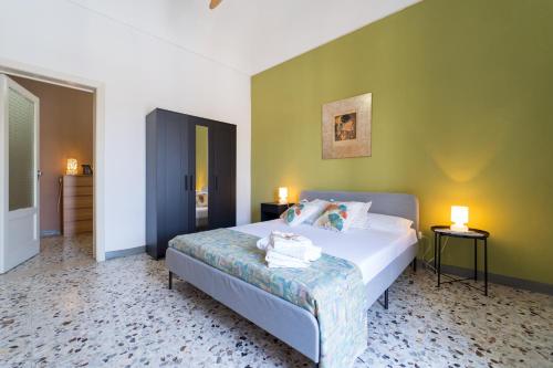 1 dormitorio con cama y pared verde en Casa Lina con terrazza en Canicattini Bagni