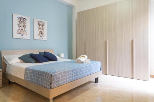1 dormitorio con 1 cama de color azul y blanco en Casa Lina con terrazza en Canicattini Bagni