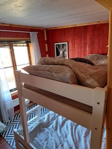 a bunk bed in a room with red walls at Guesthouse Nature Trails Sweden in Övre Älgestad
