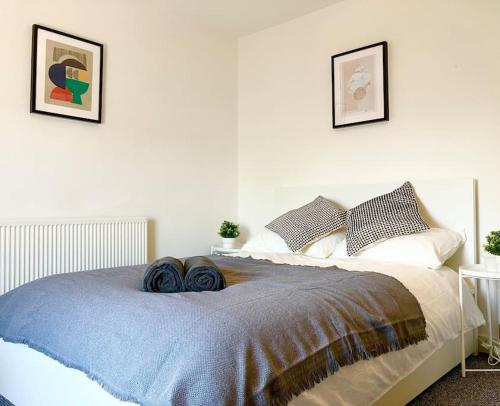 a bedroom with a bed with blue blankets and pillows at Beautiful Two Bedroom Cottage in Morriston