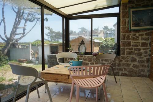 une véranda avec une table et des chaises sur une terrasse dans l'établissement Villa Joret, à Fermanville