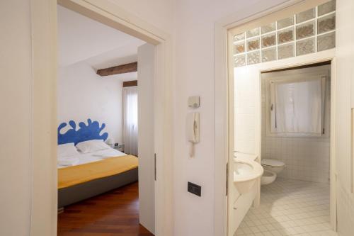 a white bathroom with a bed and a toilet at Cà Marina, appartamento in Biennale in Venice