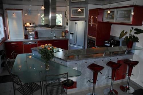 uma cozinha com um balcão e uma mesa com bancos em Chambre d'hôtes Le Cyprès Bleu em Roussillon en Isere