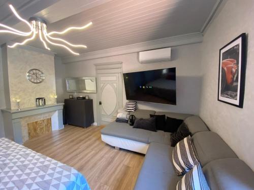 a living room with a couch and a tv at Hôtel restaurant l'escale chez mimi in Bioule