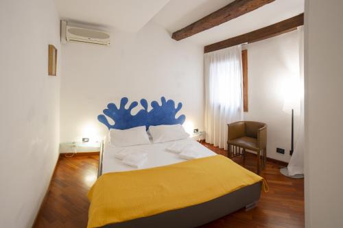 a bedroom with a large bed with a blue headboard at Cà Marina, appartamento in Biennale in Venice