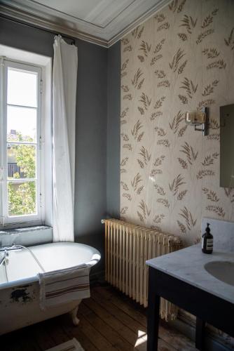 une salle de bain avec une baignoire, un lavabo et une fenêtre dans l'établissement Camellas-Lloret, à Montréal