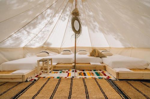 two beds in a canvas tent with a rug at Camping 3 Estrellas Costa Brava in Vall-Llobrega