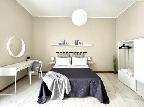 1 dormitorio con cama, escritorio y espejo en Grey Apartment en Caiazzo