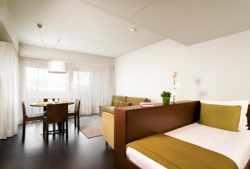 a bedroom with a bed and a table and a dining room at Aqualuz Troia Rio by The Editory in Troia