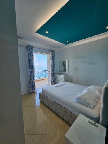 a bedroom with a bed with a view of the ocean at Amazing Sea View Apartment in Sarandë