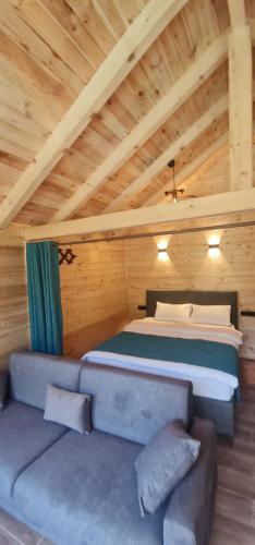 a bedroom with a bed and a couch in a room at Yayla Bungalov in Ayder Yaylasi