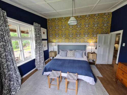 niebieska sypialnia z łóżkiem i 2 krzesłami w obiekcie On 17th Voortrekker w mieście Paul Roux