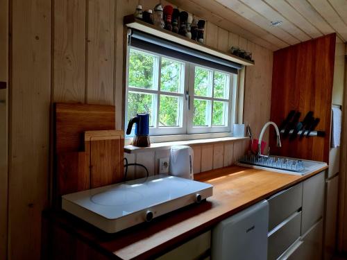 a kitchen with a white sink and a window at Maringotka KLINGER in Banská Štiavnica