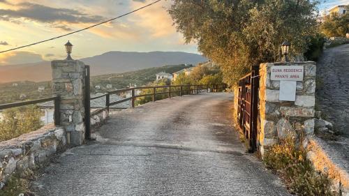 a road with a fence and a sign on a bridge at Iris Sea View Villa in Afissos