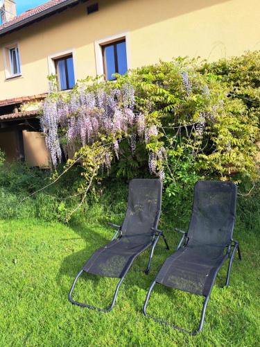Thonville的住宿－Relais Saint Vincent，两把椅子坐在房子前面的草上