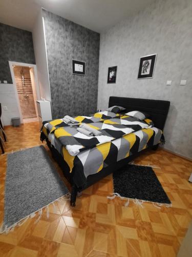 1 dormitorio con 1 cama con manta negra y amarilla en Apartman STEVAN Vrnjačka Banja, en Vrnjačka Banja