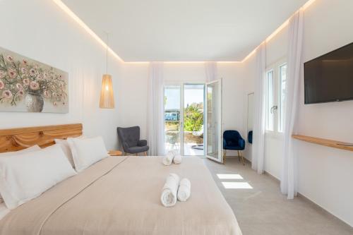 a bedroom with a large bed with two white slippers at Agrari Ninemia Mykonos in Agrari