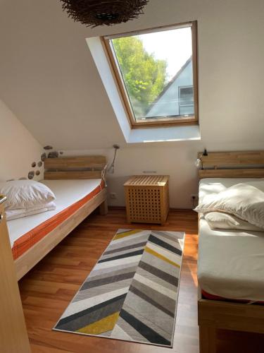 Schlafzimmer im Dachgeschoss mit 2 Betten und einem Fenster in der Unterkunft Ferienhaus Biedermann in Wiek auf Rügen 