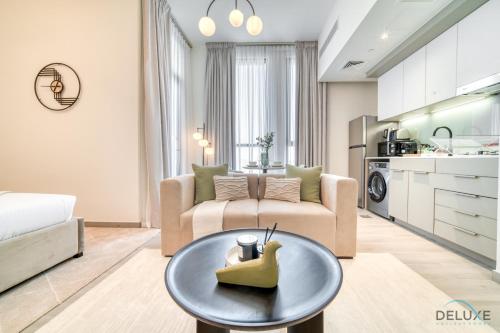 a living room with a couch and a table at Classic Studio at Mesk 1 Midtown Dubai Production City by Deluxe Holiday Homes in Dubai