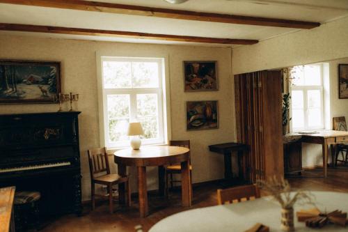 a living room with a table and a window at Lūķi, Lauku sēta in Jūrkalne